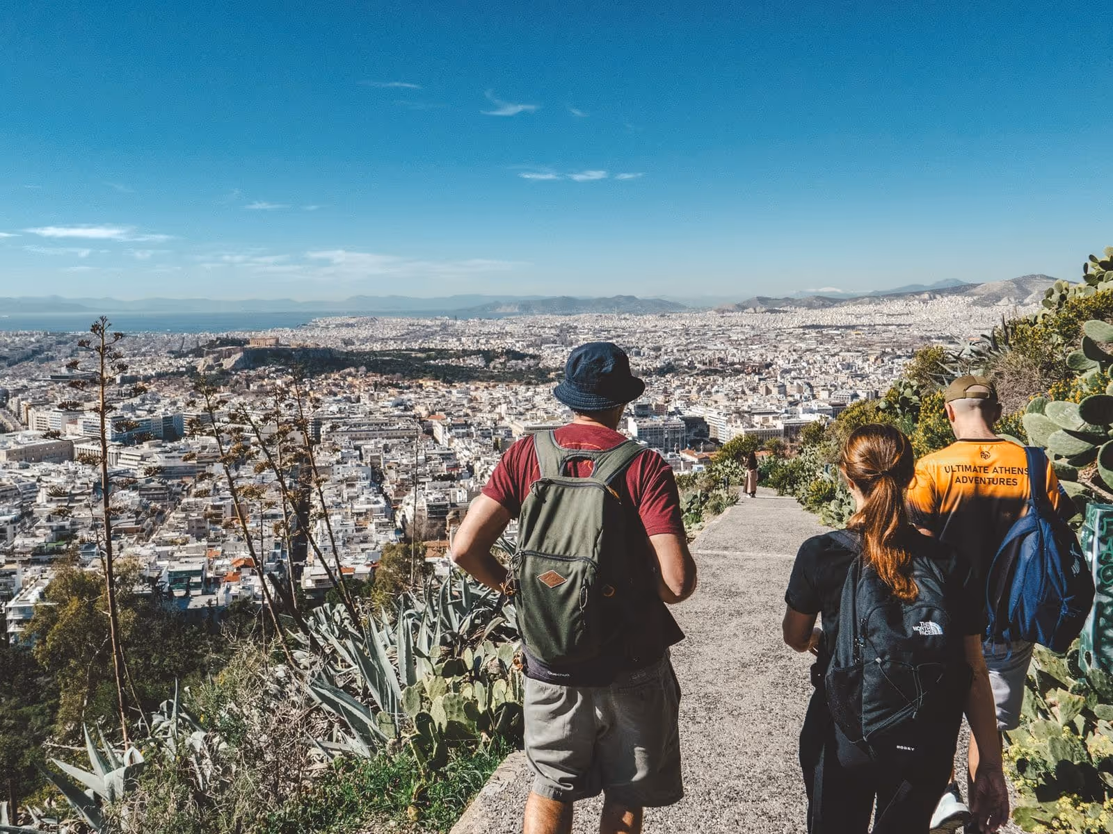 Couple taking a selfie at a Lycabettus Hill viewpoint with Athens and the Acropolis behind them