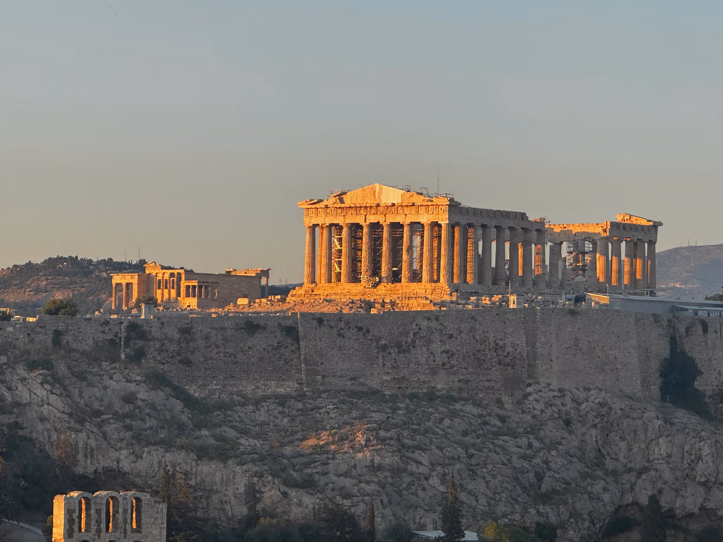 The Parthenon lit warm gold at golden hour on the Acropolis in Athens